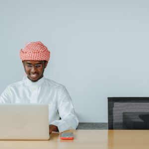 Man in White Thobe Using a Laptop