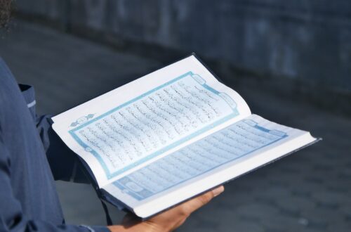 a man is holding a book with numbers on it