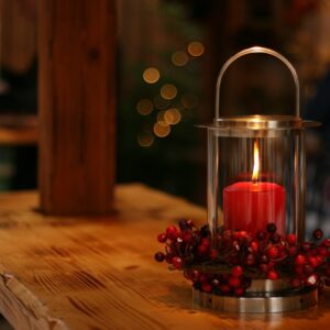 red lighted candle on brown wooden frame