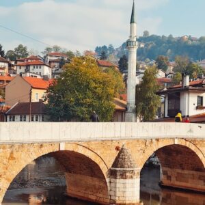 a bridge over a body of water with buildings in the background