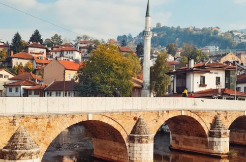 a bridge over a body of water with buildings in the background