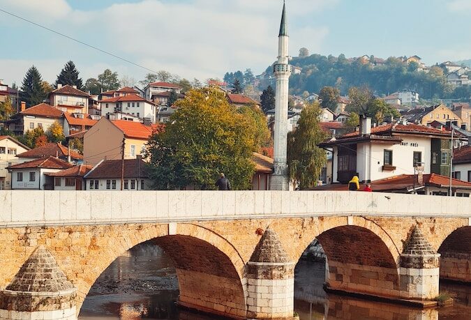 a bridge over a body of water with buildings in the background