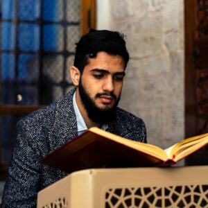 man in black and white suit reading book