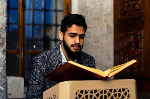 man in black and white suit reading book