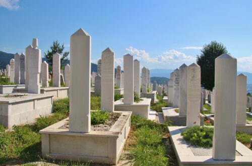 white concrete cross on green grass during daytime