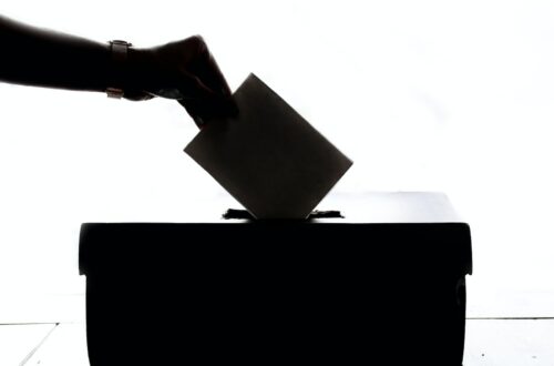 a person is casting a vote into a box